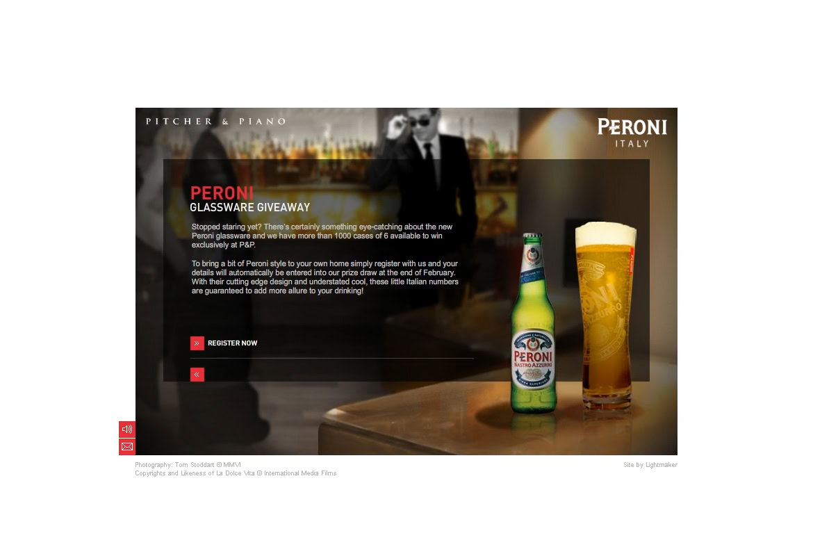 A group of people in suits standing in a bar with Peroni beer bottles and a glass of beer on a table.