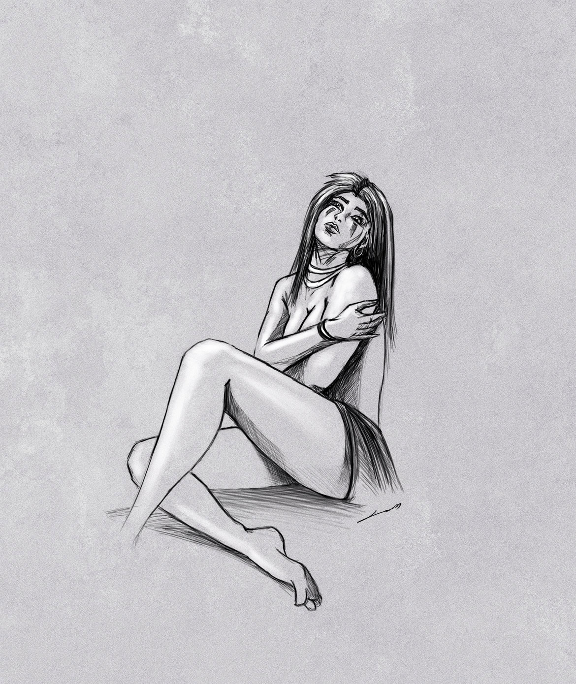 A young woman with long hair sitting on the ground, hugging her knees and looking at the camera.