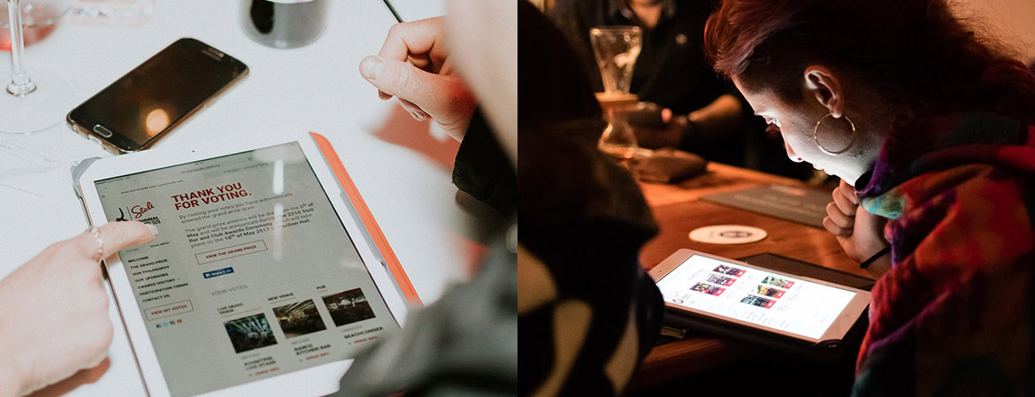 A person using a tablet with a website displayed, and a woman looking at a tablet in a dimly lit setting.