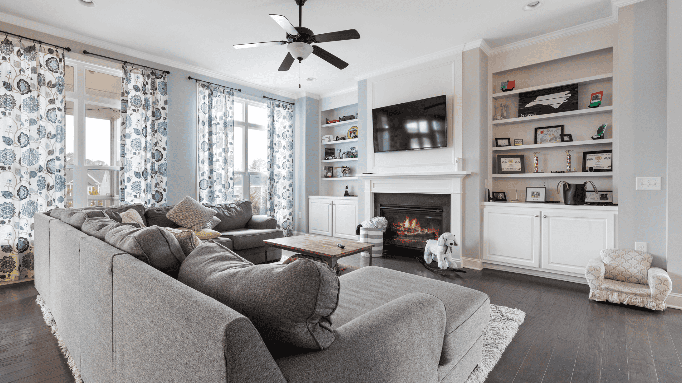 Spacious living room with large windows, fireplace, and built-in shelves for a cozy atmosphere.
