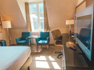 Elegant hotel room with a large window and modern furnishings.