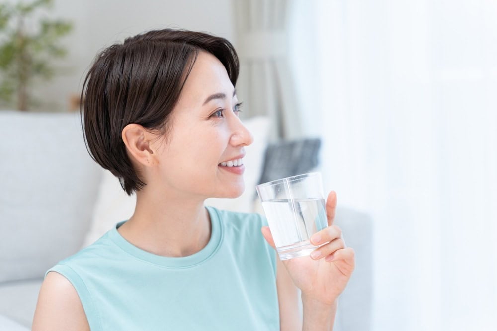Women combining hydration with hair growth vitamins