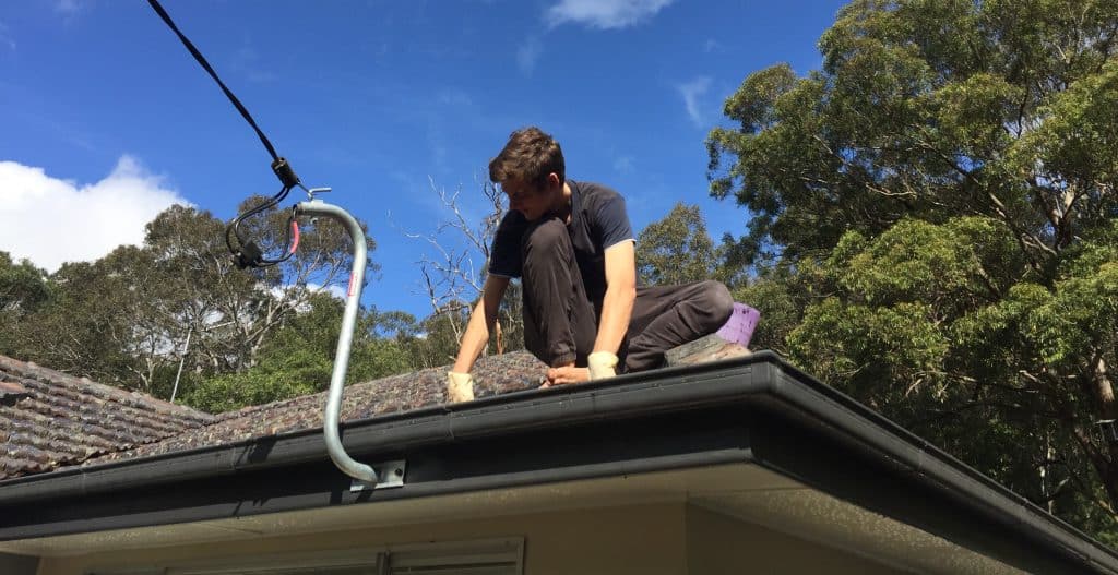 Person inspecting the roof and gutters of an Australian home