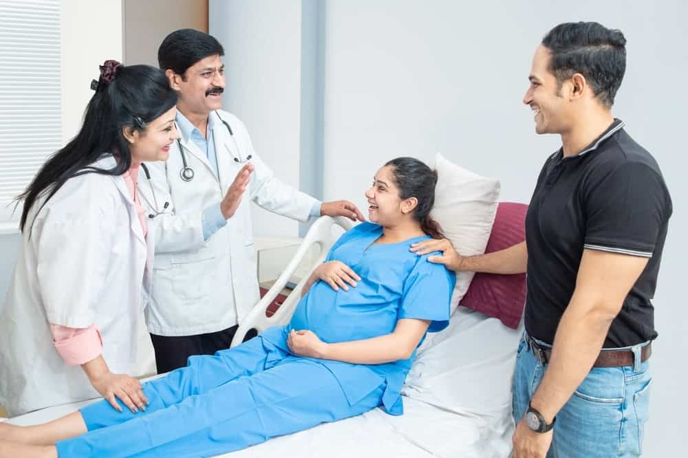 Family celebrating successful IVF treatment in a hospital room.