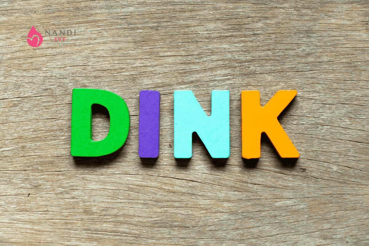 Colorful DINK letters on wooden background for fertility insights.