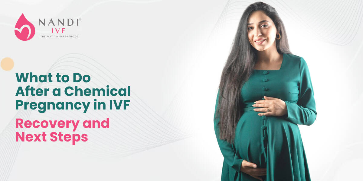Pregnant woman smiling, holding her belly, in a teal dress.