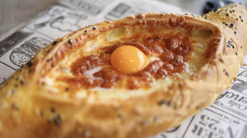 Typisch Georgische gerechten, Khachapuri Adjaruli, brood met rauw ei