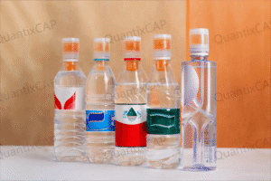 Bottled water with colorful labels and cap designs arranged on a white surface against a warm background.