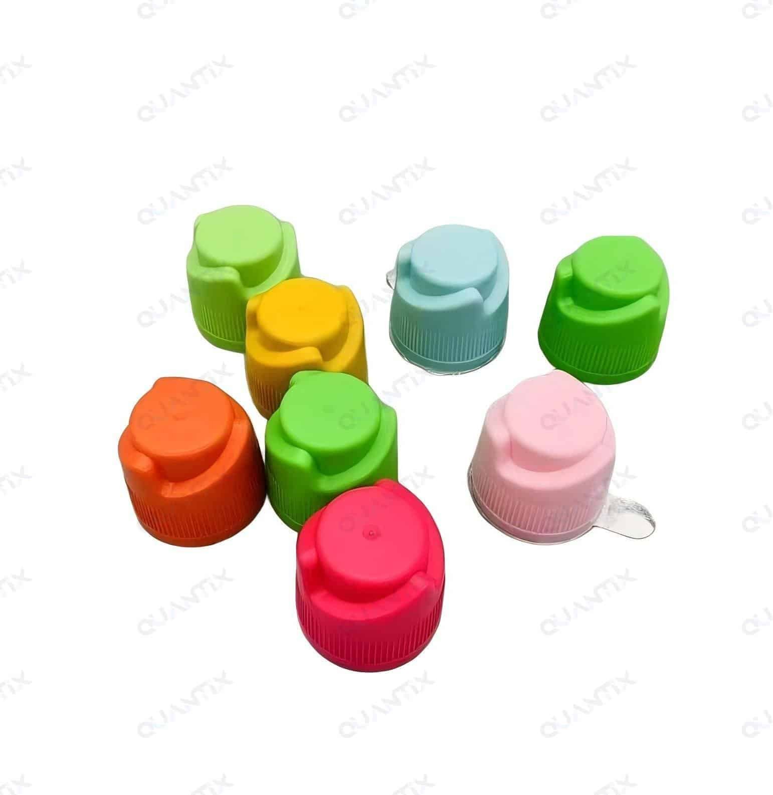Colorful paint caps with vibrant shades of green, yellow, orange, pink, blue, and red, arranged on a white surface, showcasing creative craft supplies and DIY art materials for children and adults.