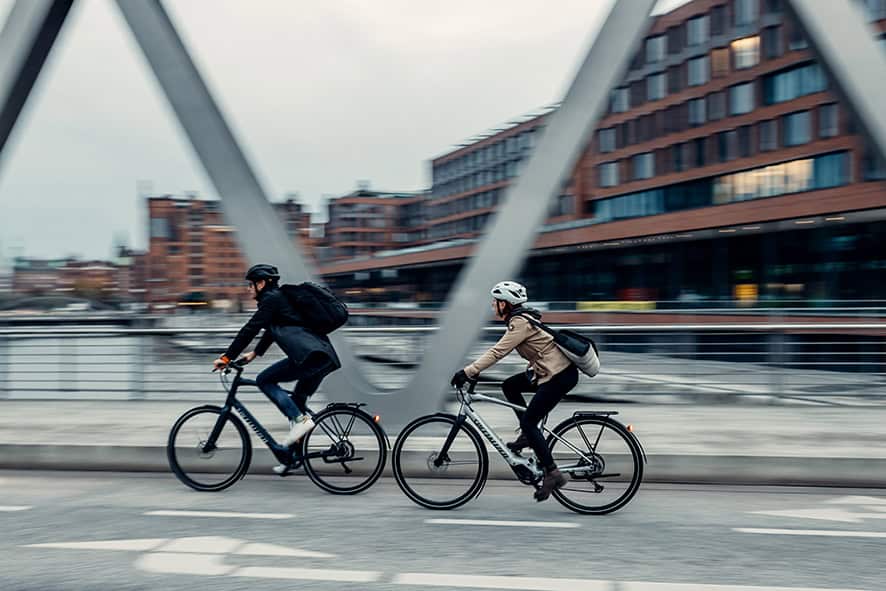 Zwei Radfahrer auf Brücke in Hilter, urbanes Umfeld, Fahrradfahren.