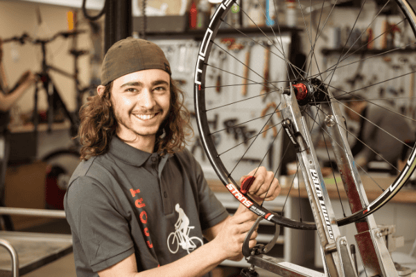 Mitarbeiter bei Rad-Sport Schriewer repariert Fahrrad in Werkstatt.