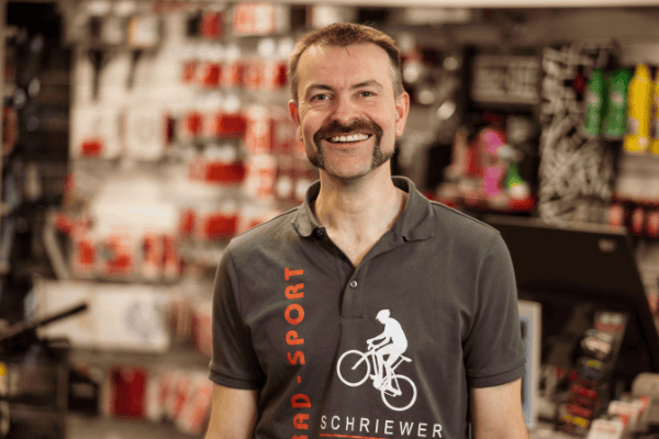 Mitarbeiter im Radgeschäft Schriewer in Hilter mit Fahrrad-Logo.