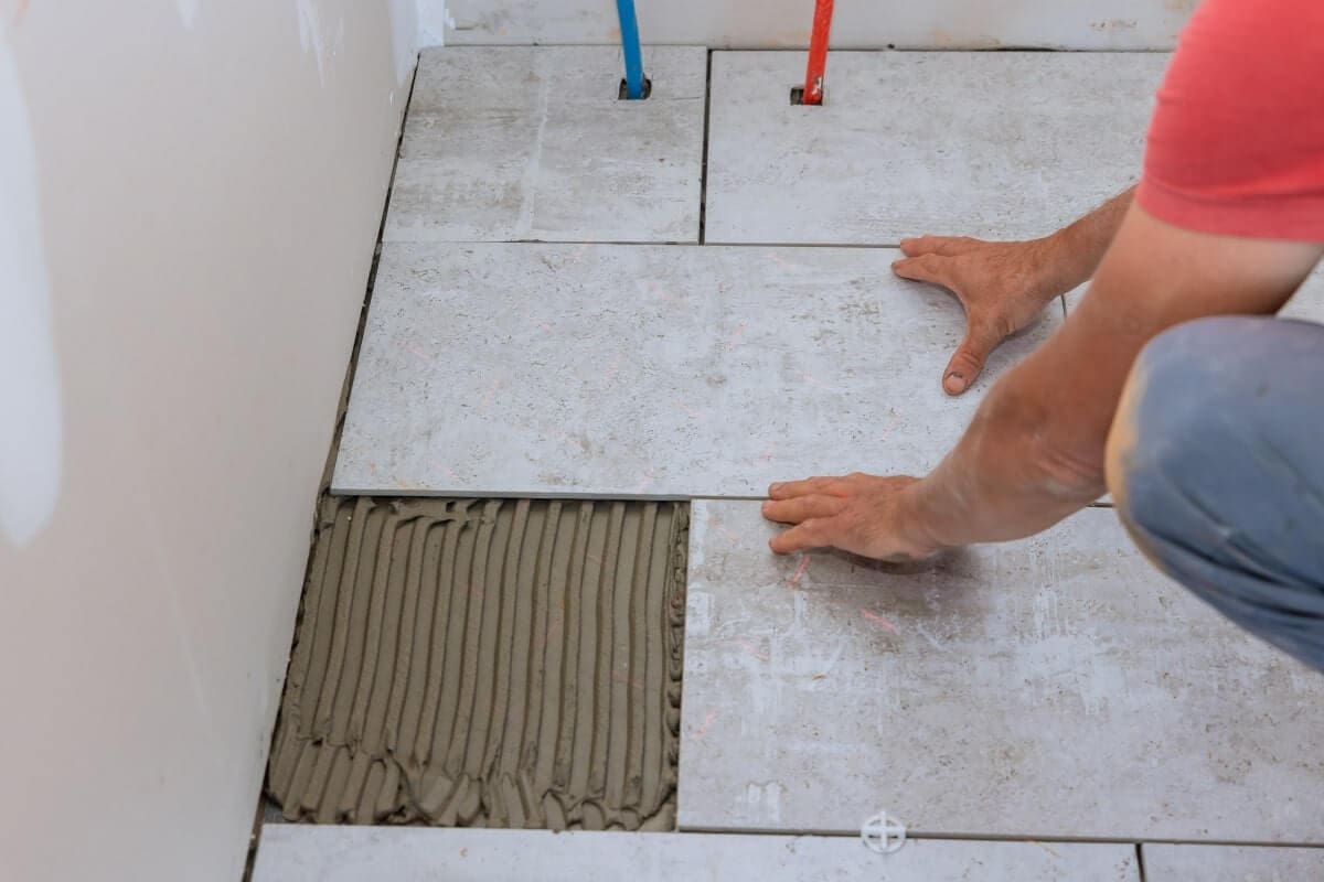 Skilled worker installing tiles on the floor for a renovation project.