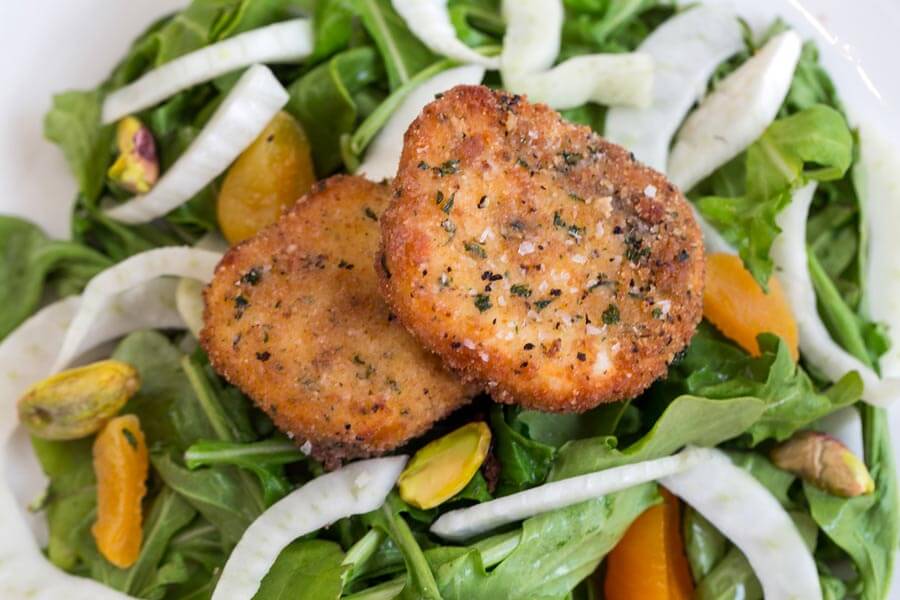 Pan-fried goat cheese medallions over an arugula salad with shaved fennel, orange segments, and pistachios.
