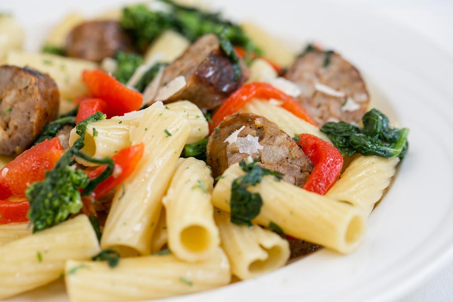 Rigatoni pasta with sliced Italian sausage, red bell peppers, broccoli rabe, and shaved cheese.