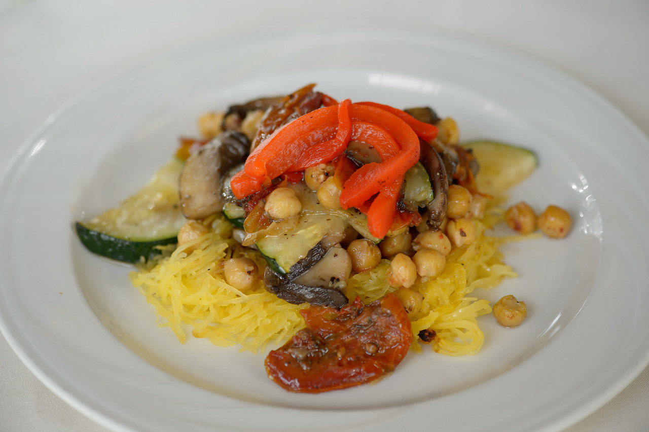 Plated spaghetti squash topped with chickpeas, zucchini, mushrooms, and red bell peppers.