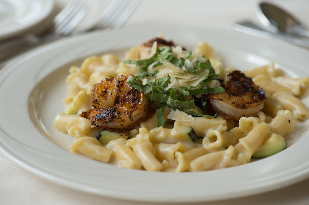 Blackened shrimp over campanelle pasta with zucchini, topped with shaved cheese and fresh herbs.