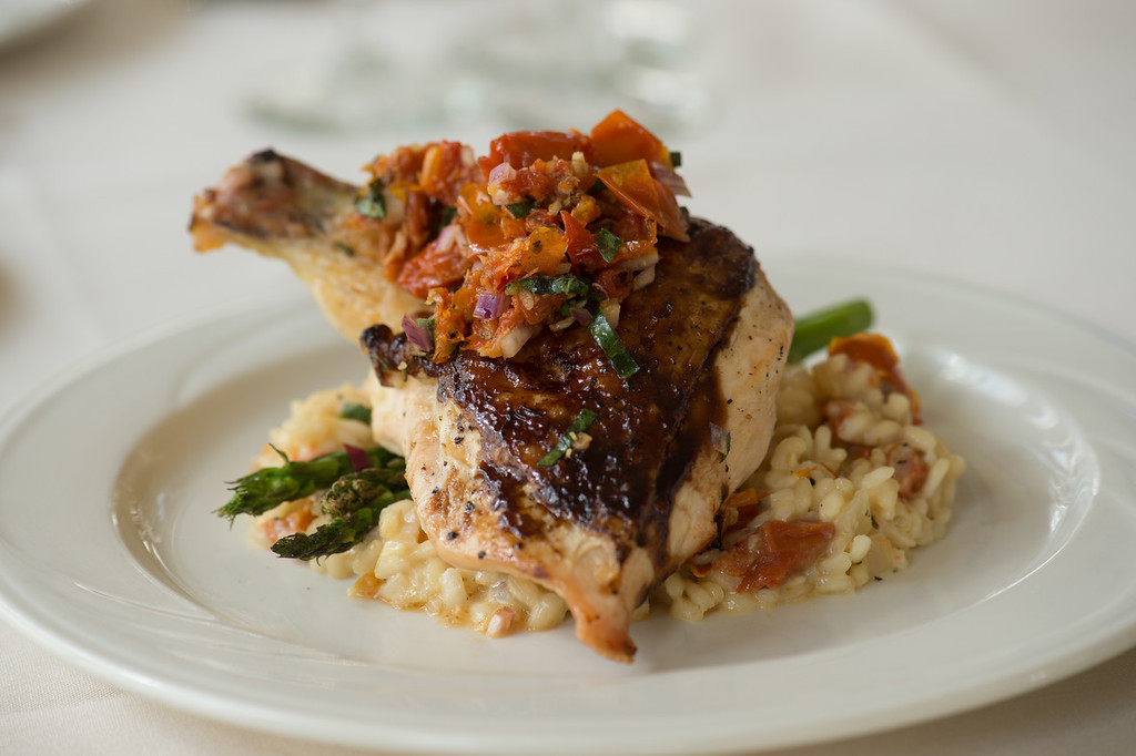 Roasted chicken breast topped with a fresh tomato bruschetta mix, served over risotto and asparagus.