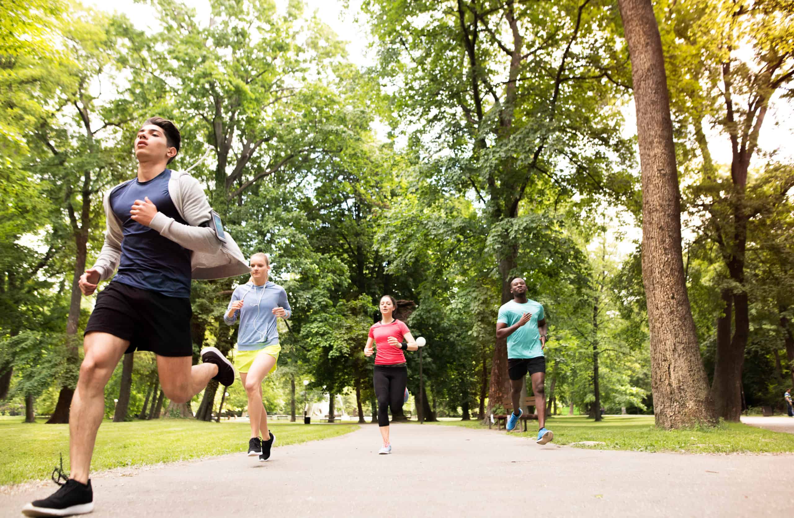 Group,Of,Young,Athletes,Running,In,Green,Sunny,Park.