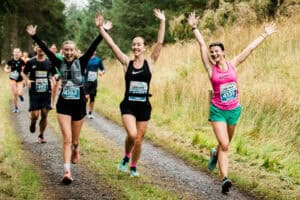 Energetic runners celebrating during a trail race in the countryside, showcasing endurance, teamwork, and running passion in a scenic outdoor setting.