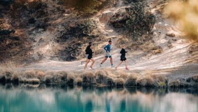 Running group training along scenic trail near water, outdoor running, fitness, endurance building, trail running tips, running insights for performance improvement.