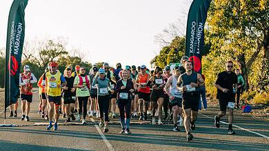 Vibrant marathon race with diverse runners at Kangaroo Island Marathon, showcasing outdoor running, endurance training, and competitive athletics in scenic autumn scenery.