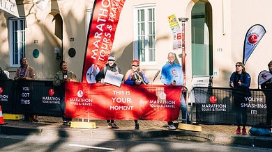 Vibrant marathon event with spectators and runners at the start line, showcasing marathon tours and travel branding, promoting motivation and the excitement of participating in a running event.