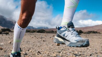 Running shoes and athletic gear for trail running on rocky terrain in outdoor mountains environment.