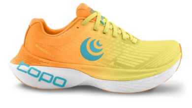 Vibrant orange and yellow running shoe with blue logo, lightweight design, and advanced sole technology for optimal performance. Ideal for marathon runners and sports enthusiasts.