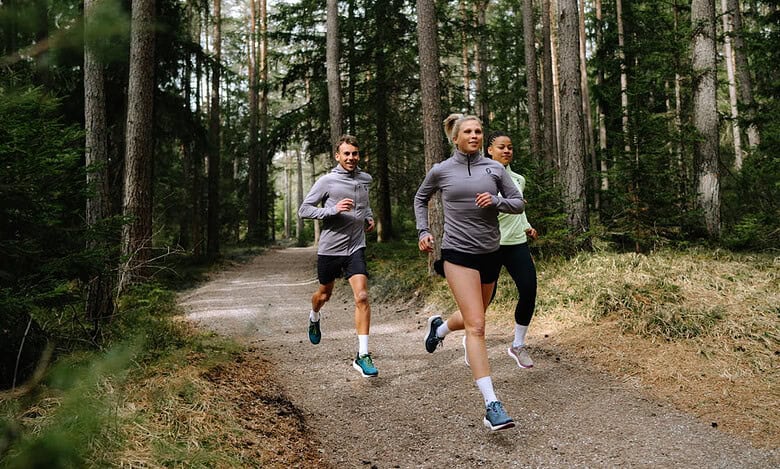 1. Group of diverse runners jogging through a forest trail, promoting outdoor running, fitness, and running insights for athletes.