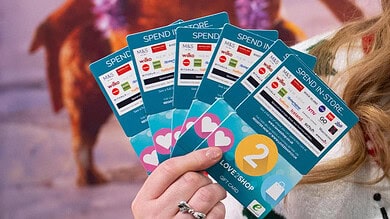 1. Close-up of a person holding Love2Shop gift cards, showcasing multiple cards with various store logos, ideal for gift card giveaways and retail promotions in the UK.