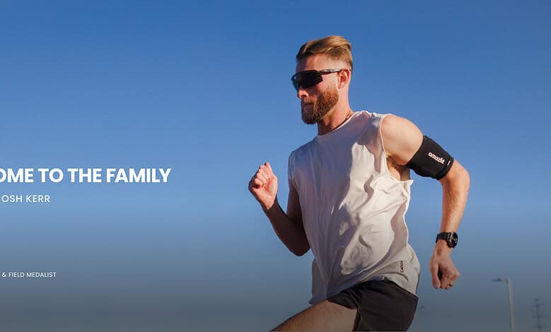 Male runner wearing a white tank top and sunglasses, running outdoors with a clear blue sky background, showcasing fitness and endurance.