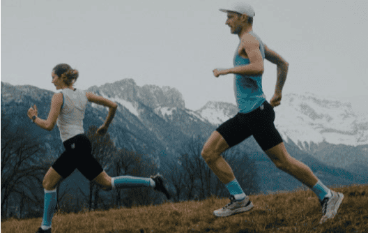 An image of a man and a girl running outdoors on a trail with mountain scenery in the background, highlighting trail running and outdoor fitness.