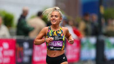 Female marathon runner smiling and running outdoors, showcasing improved energy and strength after dietary changes.