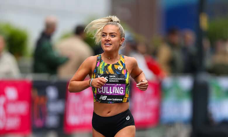 Female marathon runner smiling and running outdoors, showcasing improved energy and strength after dietary changes.