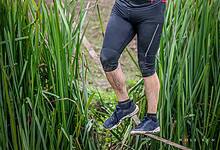 Participant crossing a water obstacle during Wolf Run's 15th anniversary event, showcasing endurance and determination.