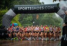 Start of the UK Athletics 5K road race in Cardiff with runners under a SPORTSSHOES.COM arch.