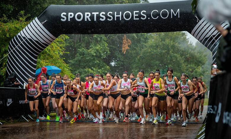 Start of the UK Athletics 5K road race in Cardiff with runners under a SPORTSSHOES.COM arch.