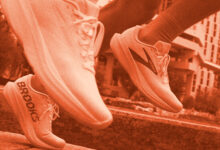 Two runners' feet in motion on a city path, showcasing athletic sneakers branded for running performance.
