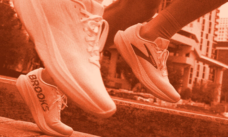 Two runners' feet in motion on a city path, showcasing athletic sneakers branded for running performance.