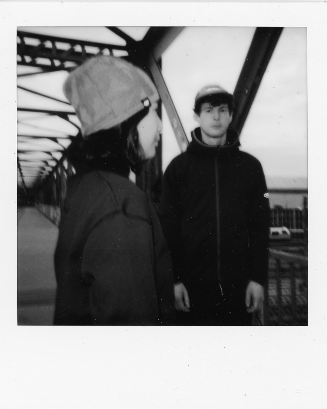 Two models wearing Ciele cold-weather headwear and layers in a black-and-white campaign photograph