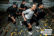Group of four runners training together at night on a cobblestone street, wearing athletic gear, with fallen leaves around, promoting night running fitness.