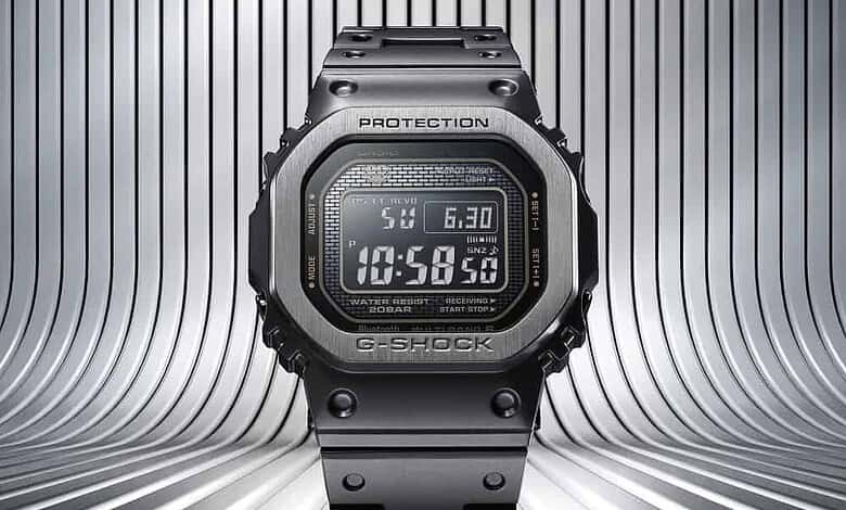 G-SHOCK digital watch with metal band, bold protection bezel, futuristic metallic backdrop.