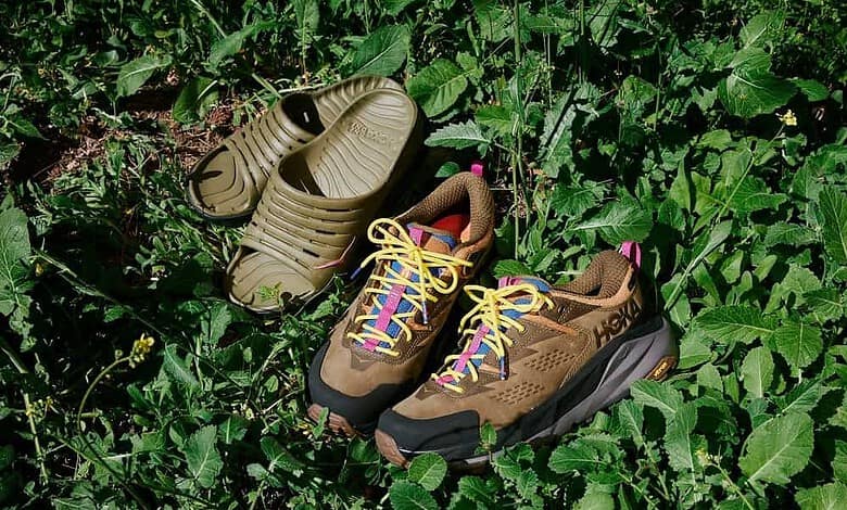 Pair of hiking trail shoes and sandals placed on green leafy ground, highlighting outdoor footwear for runners.