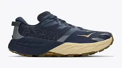 HOKA trail running shoe in navy and beige with Vibram sole, designed for comfort and durability during outdoor runs.