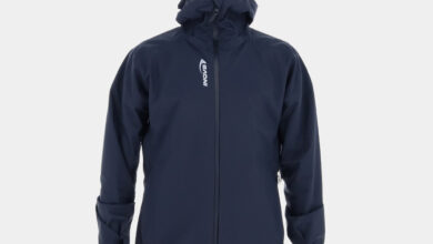 Man wearing INOV8 VentureShell waterproof jacket with hood, designed for wet-weather outdoor activities.
