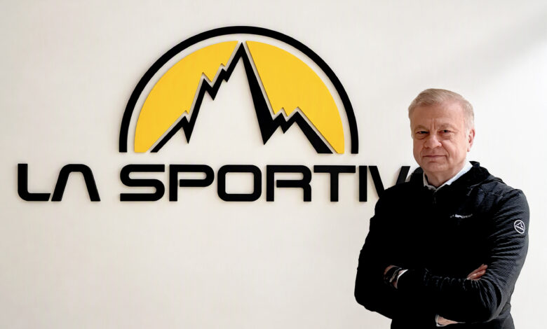 Man standing confidently with arms crossed in front of La Sportiva logo, showcasing outdoor sports and running gear expertise.