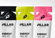 Three Pillar Performance Energy Gel packets in black, yellow, and pink with a white background, showcasing their vibrant packaging design.