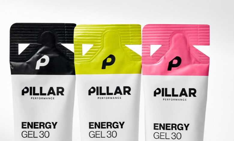 Three Pillar Performance Energy Gel packets in black, yellow, and pink with a white background, showcasing their vibrant packaging design.