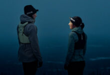 Two runners in trail running gear talking outdoors during dusk, highlighting outdoor running and fitness.